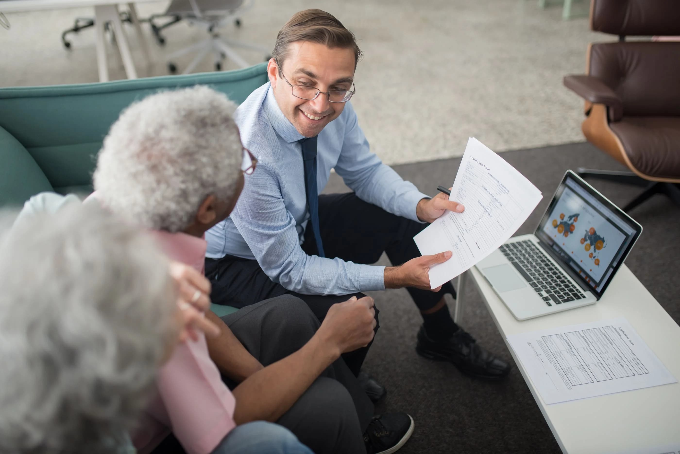 An adviser discussing documents with a couple at a desk