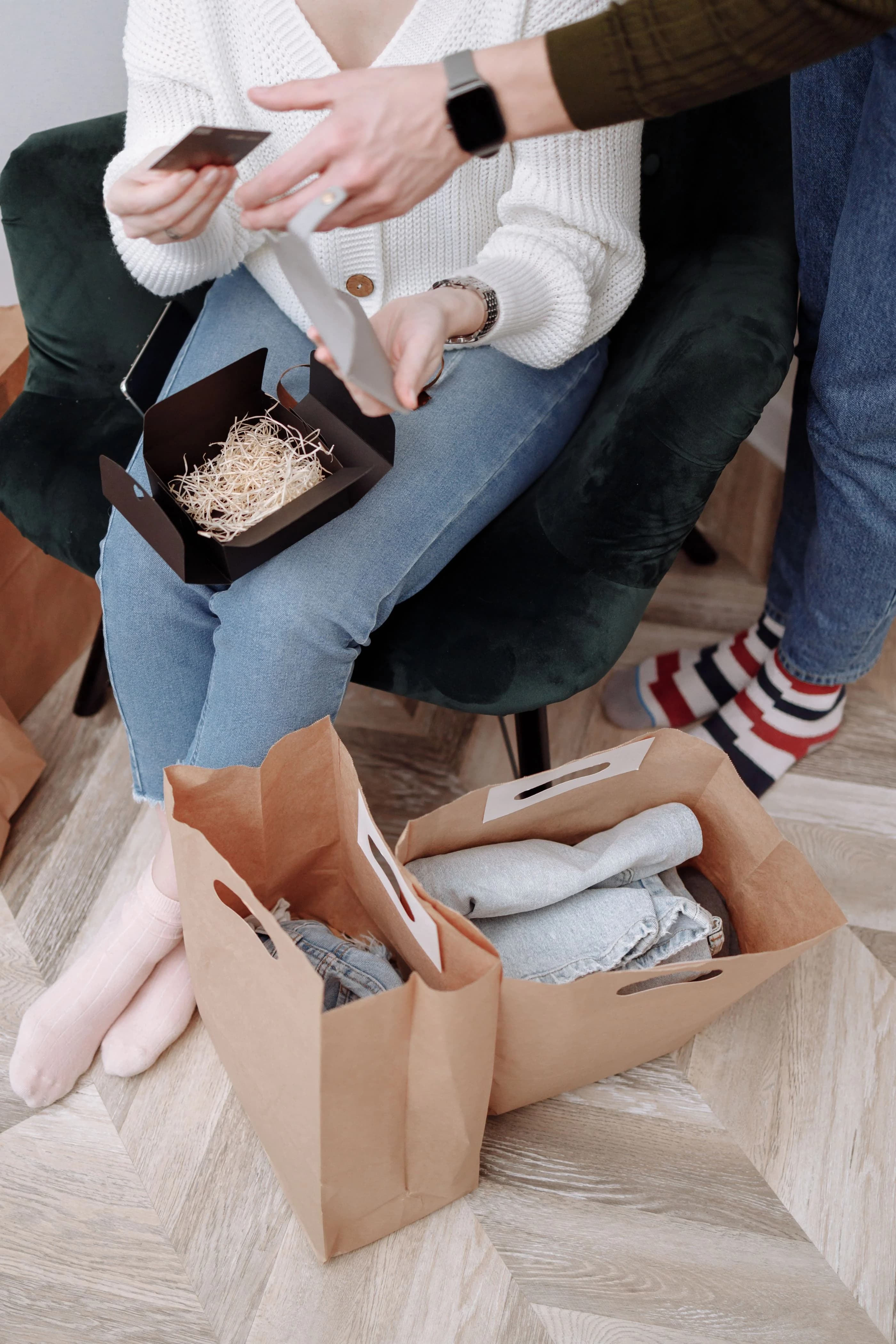 A couple unpacking clothing and shopping bags at home
